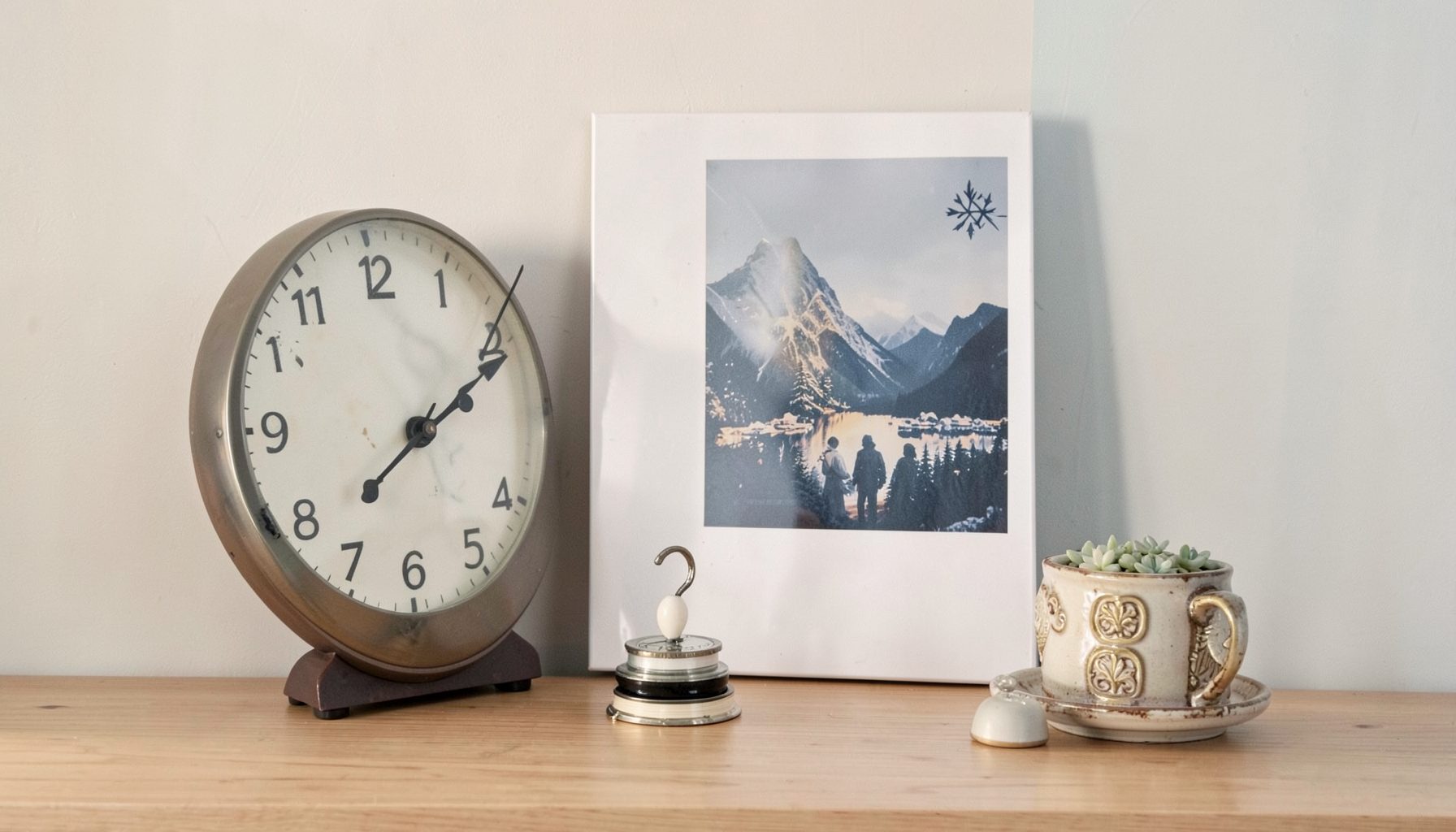 Wall clock and small decor accessories arranged near a poster display